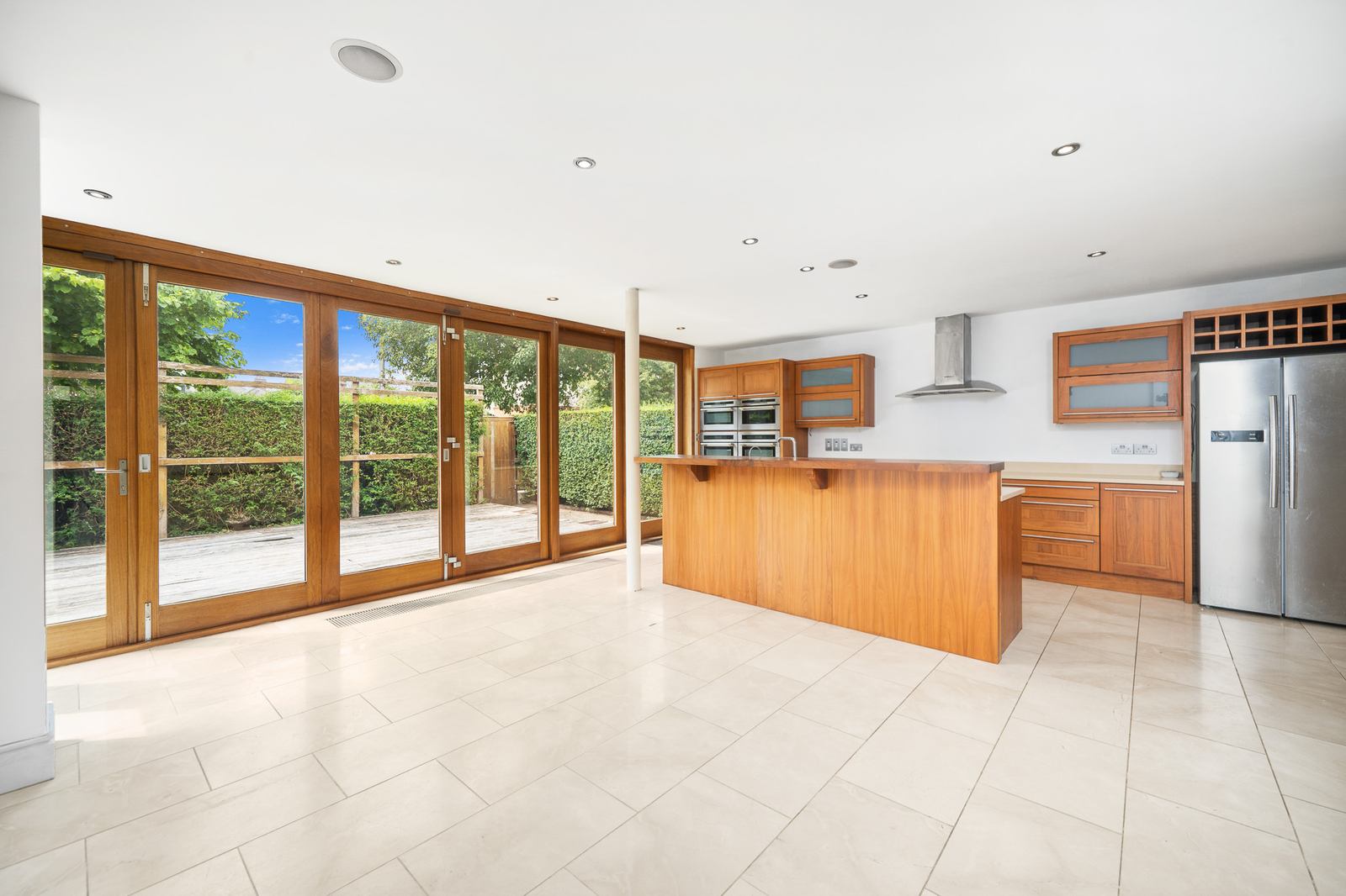 Stunning open-plan kitchen with island and floor-to-ceiling garden doors